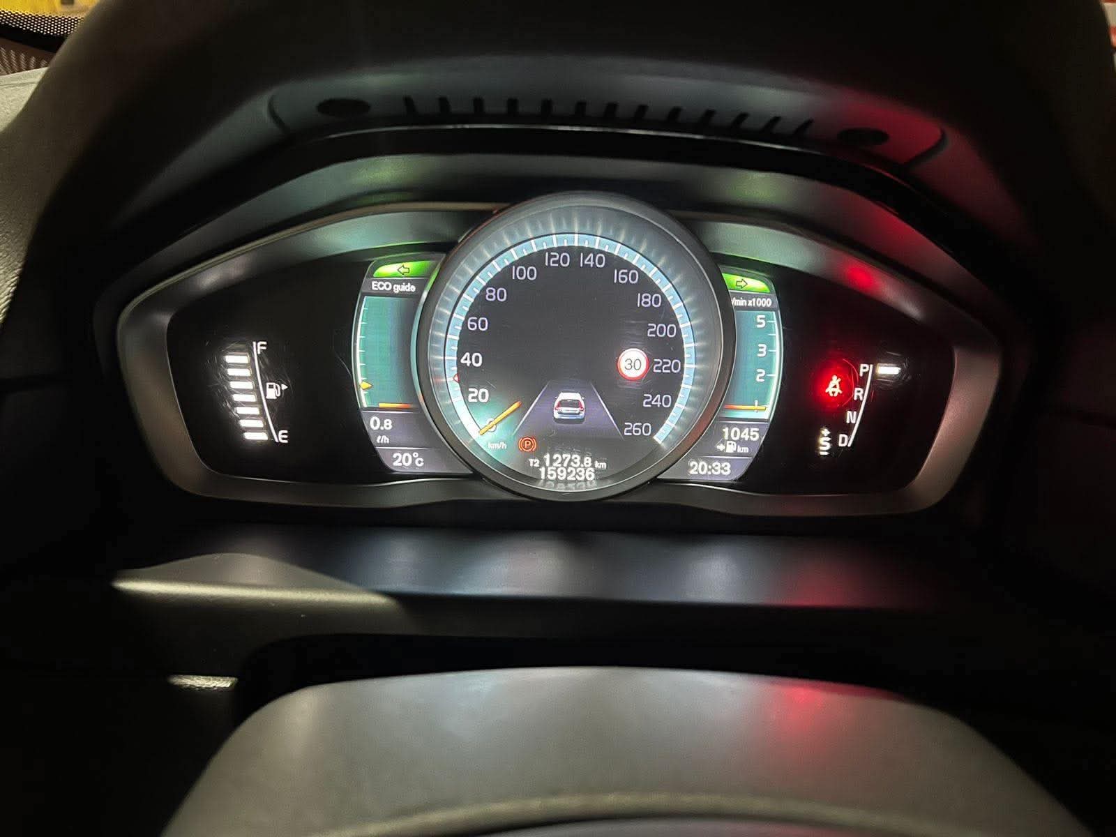 Volvo V70 dashboard and infotainment screen at night during a drive in Albania